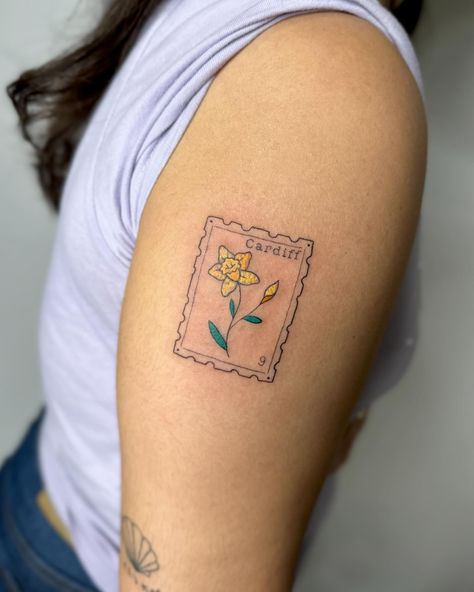 Crayon stamp tattoo to celebrate time in wales I am booking April onwards, DM TO ENQUIRE ABOUT YOUR NEXT TATTOO 💖 . . . . . . . #stamp #stamptattoo #bristol #bristoltattoo #bristoltattooartist #bristoltattoostudio #tattoo #tattoos #uktattoo #tattoouk #daffodil #fineline #finelinetattoo #finelinetattoos #colourtattoo #tattooideas #tatt #patchworktattoo . Would you get a stamp tattoo? Address Tattoo, Wales Tattoo, Tattoo Uk, Stamp Tattoo, Jewelry Tattoo, Next Tattoo, Fine Line Tattoos, S Tattoo, Color Tattoo