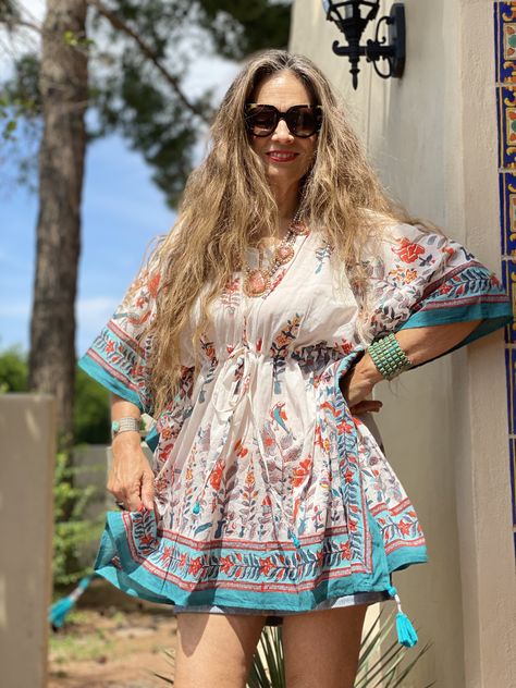 Enlightenment and bliss become effortless when you slip into our Nirvana Short Kaftan. The peaceful marine and sky blue border frames playful persimmon coloured butterflies and whimsical peacocks in a floral garden. Use this kaftan over white jeans or shorts, as a top, as acover up, or as a mini dress! The fabric is so soft you will want to keep it on forever. Tassels are hand made and hand beaded. Length 32" One size with adjustable drawstring waist. 100% cotton. Made in India Machine wash deli Kaftan Short Kurti, Kaftan Tops With Jeans, Kaftan Kurti, Short Kaftan Dress, Kurti With Jeans, Persimmon Color, Kaftan Tops, Short Kaftan, Short Kurti