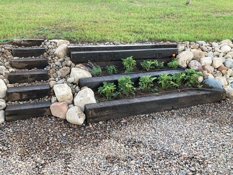 Using some old Railroad ties and rock, we made this corner beautiful in our yard. Flower Bed With Railroad Ties, Railroad Tie Garden Border, Landscaping With Railroad Ties Ideas, Old Railroad Ties Ideas, Fire Pit With Railroad Ties, Railroad Tie Retaining Wall Ideas, Railroad Tie Fire Pit Area, Railroad Ties Landscaping Border, Railway Ties Landscaping