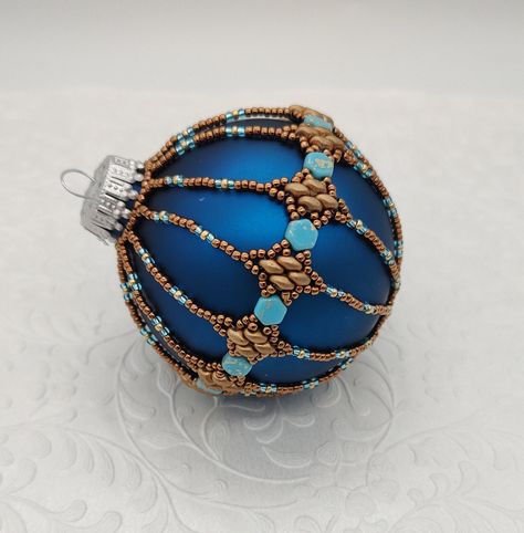 "This beautiful 3\" dark blue glass ornament is covered with woven bronze superduo beads, turquoise and gold honeycomb beads and bronze and aqua seed beads.   It features Deb Roberti's Silky Stacker pattern in the main band. A genuinely unique and versatile hostess gift, housewarming gift or Christmas gift for your family and friends. This ornament can be used year round, not just for the holidays. It will add an elegant air to your decorations as the beads give them a hint of antique or vintage. It will look fantastic hanging on your tree, in the window, or as a part of a larger decoration. Standard glass ornament included. If you'd like one in  different colors, I can customize.  Please contact me if you'd like a custom ornament. Ready to ship.  Attention! Colors may look different depen Beaded Holiday Ornaments, Beaded Ornaments Diy, Beaded Christmas Decorations, Superduo Beads, Spider Web Decoration, Beaded Ornament Covers, Seed Bead Jewelry Patterns, Holiday Beading, Large Decor