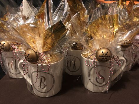 Take a pretty monogram mug from bed bath and beyond, inside wrap a Starbucks coffee gift card and Hershey chocolate kisses on a gold tissue paper. Wrap all around with clear cellophane paper using ribbon to tie and adding a jingle bell for final touch. #starbucks #bedbathandbeyond #hersheyskisses Gifts In A Cup Ideas, Coffee Mug Gift Wrapping Ideas, Clear Gift Wrapping Ideas, Gift Cups Filled, Christmas Coffee Gifts Ideas, Wrap Mug Gift, Cellophane Gift Wrapping Ideas, Christmas Return Gifts, Gift Mugs Ideas Filled