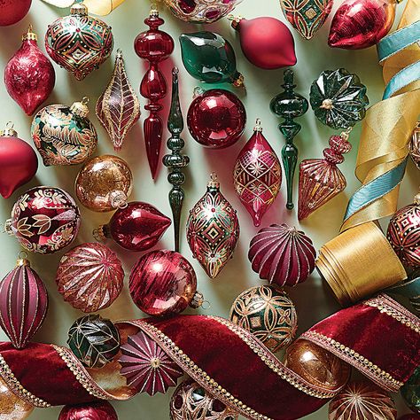 With its jewel tones and geometric accents, this warm and sophisticated ornament collection features traditional burgundy highlighted with pops of red and teal. Each glass ornament is decorated by hand, accented with glitter and features a metal cap and ribbon for easy hanging. Handcrafted, hand-embellished glass ornaments. 40-piece and 6-piece sets. 40-piece set includes ball, onion, teardrop and finial shapes. Each ornament is topped with a metal cap and hook for hanging. For indoor use. Store Collectible Christmas Ornaments, Jewel Tones Christmas Tree, Jewel Tone Christmas Decor, Jewel Toned Christmas, Burgundy Ornaments, Jewel Tone Christmas, Future Christmas, Chinoiserie Ornaments, Burgundy Christmas