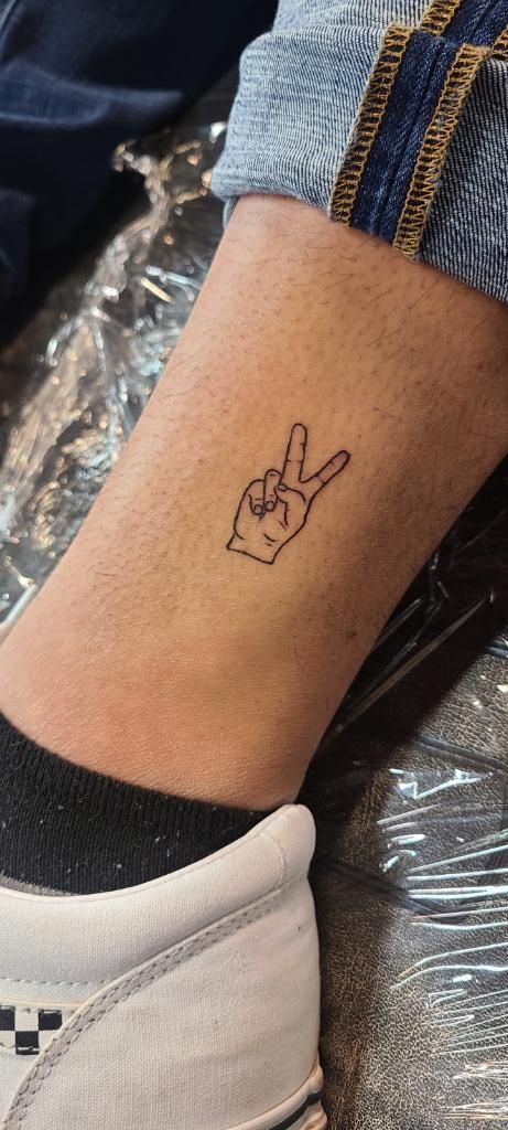 Small Leg Sleeve Tattoo, Mini Peace Sign Tattoo, Peace Tattoos Men, Peace Sign Fingers Tattoo, Peace Word Tattoo Fonts, Peace Love Positivity Tattoo, Power Sign Tattoo, Simple Peace Sign Tattoo, Tattoo Ideas Peace Sign