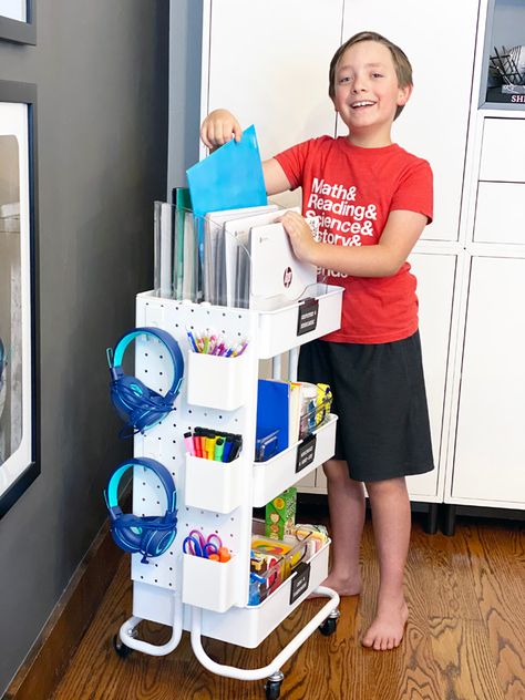 Organize all the school supplies for at home learning in a rolling cart with space for chromebooks, folders, workbooks, headphones, and more. Homework Supplies Organization, How To Organize School Supplies At Home, How To Organize School Supplies, Homework Cart For Kids, School Supplies Storage At Home, School Supply Storage At Home, Rolling Cart Organization Classroom, Workbook Storage, Organizing School Supplies At Home