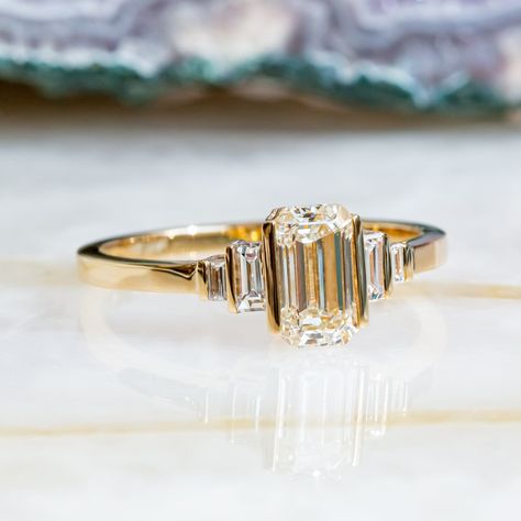 Beautiful Art Deco Engagement set with 1.11 carat of Emerald Cut cut diamond mounted in 14K Yellow gold.   Vintage Bars on top of Emerald cut & Baguettes, with Diana Rafael's light performing diamonds, makes a stunning ring, you won't ever take off!  Setting -Total Carat Weight: 1.11 carat -14K YellowGold -Size: Resizable - any size is availzble! Ask us!  -Certificate Of Authenticity Included  Main Diamonds: -Emerald Cut  -0.94 Carat -Color: G -Clarity: VS1 (Enhanced) -Cut:  Cut -Dimensions: 7.25 x 4.20  *Clarity Enhanced *Processing time* Unbeatable processing time of 3-5 business days! - custom orders is 5-7 Business days. *Shipping** We ship with FedEx Express shipping! Most items are delivered within 48-96 hours! ------------------------------------------------------------------------- 3 Stone Art Deco Ring, Antique Emerald Cut Ring, Antique Bezel Ring, Vintage Emerald Cut Engagement Ring Set, Bar Set Engagement Ring, Yellow Emerald Cut Engagement Ring, Vintage Wedding Rings Emerald Cut, Emerald Cut Engagement Ring Art Deco, Baguette Emerald Engagement Ring