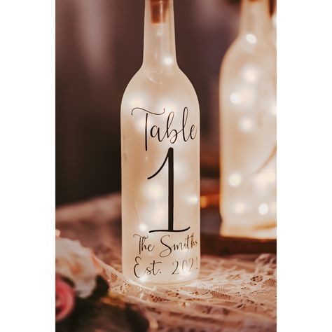 Illuminate your wedding reception with our elegant Light Up Wine Bottle Wedding Table Numbers--perfect for adding a touch of charm to your table decor and serving as unique wedding table numbers. This delightful bottle lamp isn't just a simple accent piece; it's a radiant addition to your rustic wedding table decor, sure to enchant your guests and elevate the ambiance of your special day. Enhance your wedding centerpieces with this luminous treasure, designed to create an unforgettable atmospher Rustic Table Decor Wedding Receptions, Wedding Decorations On A Budget Table, Centerpieces Wedding With Table Numbers, May Wedding Centerpieces Diy, Cool Wedding Centerpieces, Bronze Wedding Table Decor, Modern Rustic Wedding Table Decor, Cute Wedding Centerpiece Ideas, Wedding Table Centerpieces Elegant Simple