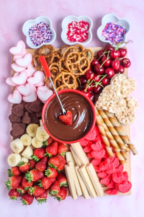 Looking for a fun and easy way to celebrate Valentine's Day? Try this delicious Valentine's day chocolate fondue board! Valentines Day Chocolate Fondue Board, Valentines Food Platters, Galentines Charcuterie Board Ideas Sweets, Fun Charcuterie Board Ideas Valentines, Valentines Day Fondue Dinner, Valentines Board Ideas Food, Valentines Platter Ideas, Valentine Fruit Tray Ideas, Valentine Platter Ideas