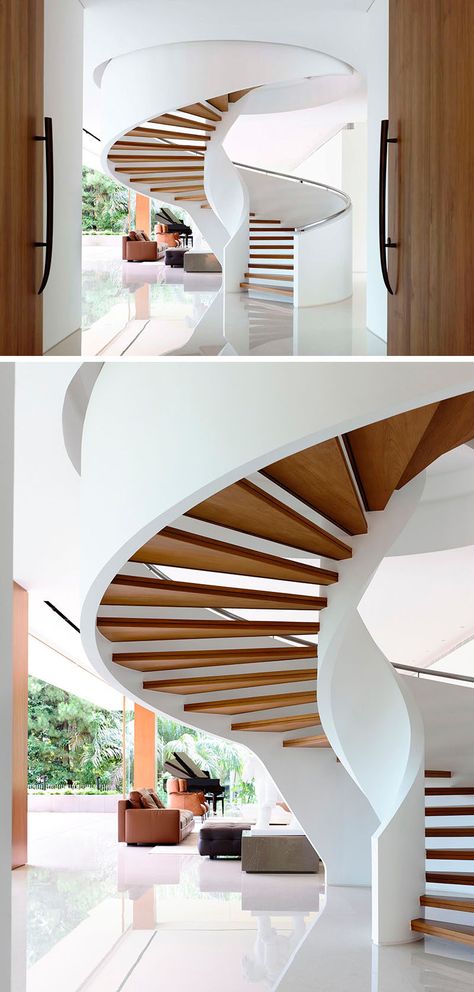 A grand spiral staircase created by floating wood treads between the two white sides rises up into the next floor and welcomes people as they enter the home. Spiral House, Staircase Spiral, سلالم حلزونية, Stairs Interior, Modern Staircases, Spiral Stair, Escalier Design, تصميم للمنزل العصري, Stair Case