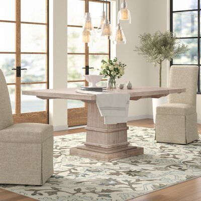 A classic design gets a dash of countryside style with this rectangular dining table. Crafted from solid acacia wood with veneers, it sports a neutral woodgrain stain with distressed details for an airy and weathered look. Molded details along the pedestal base bring an architectural appeal. Up above, the top is complete with two removable leaves that let you extend this table to seat six comfortably. Full assembly is required. Color: Natural Gray | Rosalind Wheeler Extendable Dining Table Wood Extendable Dining Table Wood, Coastal Dining Table, Square Kitchen Tables, Dining Table Wood, Countryside Style, Sunroom Designs, Big Table, Trestle Dining Tables, Solid Wood Table