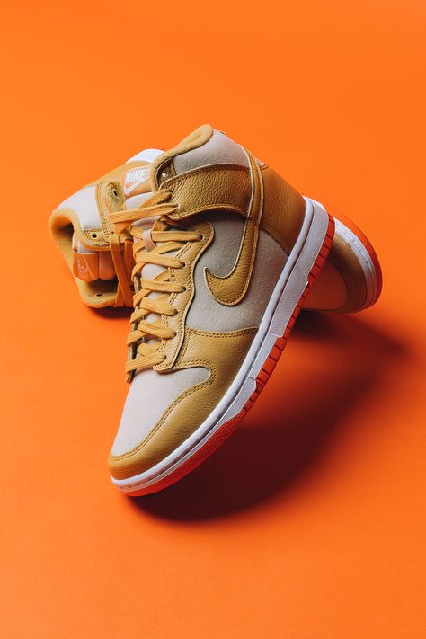 This take on the Dunk High sees the silhouette's classic leather base swapped with a course, tan-coated canvas material. The neutral upper is covered in shades of wheat and gold and create a scheme that's effortless to style, all atop a bright orange outsole that adds some pop underfoot.⁠ Shop now online. Product Photography Shoes, Shoe Product Photography, Shoes Photography Ideas, Nike Air Presto Black, Sneaker Photography, Sneakers Photography, Nike Air Huarache White, Vans Boots, Shoe Photo