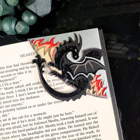 Introducing our Black Dragon Paper Corner Bookmark, a must-have for book lovers and fantasy enthusiasts. The intricate black dragon design, crafted with sparkling flames, will transport you to a world of magic and wonder every time you read. Elevate your reading experience with this luxurious and exclusive bookmark. Made with a combination of printed and textured cardstock and gold metallic vinyl for added shine. *Please note - due to the spacing on this design, we cannot add a name to this book Bookmark Corner Ideas, Book Mark Holder, Mens Bookmark, Felt Bookmarks Diy, Bookmarks Handmade Aesthetic, Diy Book Marks, Book Marks Design Ideas, Dragon Paper, Cool Bookmarks