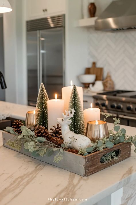 Festive kitchen centerpiece with lit candles, miniature trees, and a porcelain deer in a wooden tray. Christmas Counter Top Decorations, Above The Sink Christmas Decor, Christmas Wooden Tray Ideas, Kitchen Christmas Centerpiece Ideas, Christmas Kitchen Countertop Decor Ideas, Aesthetic Christmas Decor Kitchen, Christmas In Kitchen, Kitchen Bar Christmas Decor Ideas, Kitchen Winter Decorating Ideas