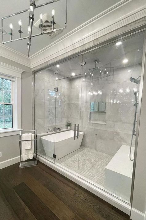 Effortlessly charming, this elegant primary bathroom by @amberhodorek featuring a #ThermaSol Steam Shower, white marble tile and rich hardwood floors is the perfect spa retreat. 🤍 | Thermasol | Thermasol Steam Shower | Thermasol Steam | Design Inspiration | Interior Design | Design Trends | Shower Trends | Shower Thoughts | Home Decor | Bathroom Decor | DIY Full Bathroom Remodel, Luxury Master Bathrooms, Bathroom Redesign, Master Bath Remodel, Bathroom Remodel Designs, Bathroom Remodel Shower, Dream House Rooms, Bathroom Inspiration Decor, Bathroom Design Luxury