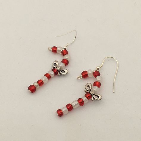 Fun Christmas earrings, beaded candy cane design dangle earrings.  Created with red and white glass seed beads and featuring a a pewter bow.  The canes hang from a sterling silver ear wire.  A great idea for Christmas stocking fillers. The cute earrings drop 4cm in length. They are available to be shipped immediately and will arrive packaged in a kraft paper pillow box ready to give as a gift or as a gift for yourself! Christmas Jewelry Aesthetic, Diy Christmas Earrings Beads, Christmas Seed Bead Jewelry, Beaded Earrings Christmas, Christmas Earrings Beaded, Christmas Earrings Diy, Diy Christmas Jewelry, Christmas Seed Bead, Beaded Christmas Earrings