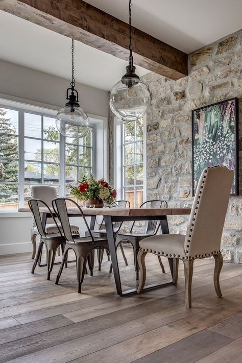 Picture Of a modern French country kitchen with a stone accent wall, a wooden table and metal chairs and a leather chair plus pendant lamps French Farmhouse Dining Room, Modern French Country Kitchen, Stone Wall Interior Design, Stone Walls Interior, Farmhouse Dining Rooms Decor, Stone Accent Walls, Modern French Country, Stone Interior, French Country Farmhouse