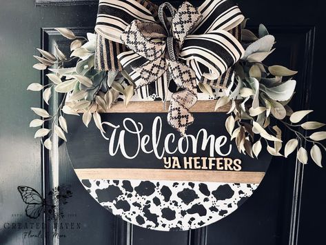 18” Hand-Painted Wood Round Door Hanger – Cow Print “Welcome Ya Heifers!” Add a touch of farmhouse charm to your home with this 18-inch wood round door hanger! Hand-painted in a trendy cow print design, this piece is perfect for bringing rustic warmth and humor to your entryway. Featuring bold lettering that says, “Welcome Ya Heifers!”, this door hanger is a fun and inviting way to greet your guests. The natural wood finish complements the playful design, making it a perfect fit for any far... Round Door Hanger Ideas, Cow Print Welcome Sign, Door Hanger Ideas, Cow Print Design, Hanger Ideas, Round Door Hanger, Bold Lettering, Unique Fall, Sign Door