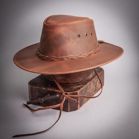 Unique and affordable, the Leather Bushman Outback Hat lacks in neither style nor craftmanship. It offers ultimate sun and rain protection while still being one of our more stylish and attractive hats. Offered in stunning copper or brown with a handcrafted braided leather band, this hat is equally at home on the ranch, in the mountains, or at your favorite patio.  #hats #leatherhats Australian Hats, Aussie Hat, Australian Hat, American Hat Makers, Vacation Hat, American Hat, Outback Hat, Australian Outback, Rain Protection