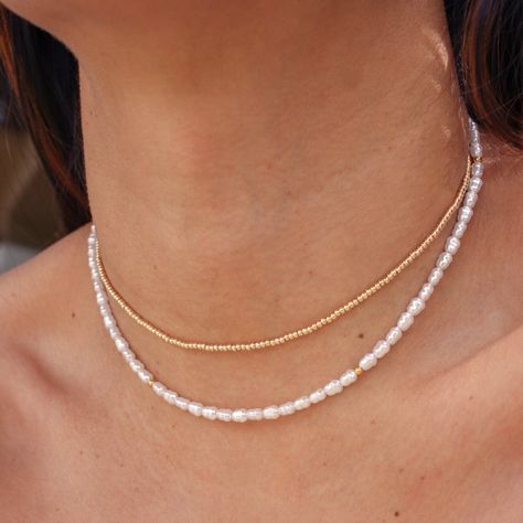 Get ready to fall in love with the Leia Necklace! This stunning piece features faux pearls and gold beads, delicately strung on a gold plated stainless steel chain. With its minimalist design and durable construction, the Leia Necklace is perfect for everyday wear or as a beautiful addition to your beach jewelry collection. • 18k PVD Gold Plated over Stainless Steel chain• Faux Pearls• Gold plated stainless steel bead• Length: 14.5" + 2" extender Fresh Pearl Necklace, Beads Craft Jewelry, Pearl Beach, Beads Craft, Beach Necklaces, Gold Bead Necklace, Craft Jewelry, Jewellery Designs, Stylish Jewelry