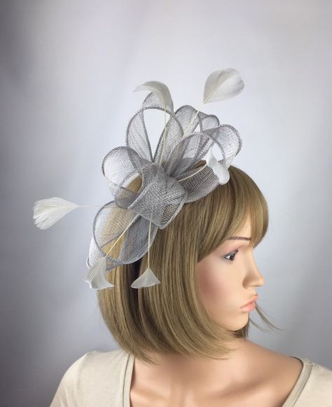 Pretty Elegant grey fascinator for any outfit, for a wedding, mother of the bride or guest, a day at the races, a tea party, bbq, dinner dance or a memorable occasion, garden parties, hen night, etc Striking grey bow fascinator is made from sinamay and complemented by beautiful feathers. This quality fascinator is mounted on a 1.3 cm satin headband so is comfortable to wear. The fascinator can be moved along the headband so can be adjusted to position in varying angles. Approximate size of fasci Hair Styles With Hats, Silver Fascinator, Grey Fascinator, Yellow Fascinator, Cream Fascinator, Bow Fascinator, Ascot Ladies Day, Ivory Fascinator, White Fascinator