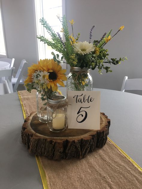 Burlap And Sunflower Table Decorations, Rustic Wedding Centerpieces Sunflowers, Centerpieces With Sunflowers Simple, Sunflower Mason Jar Wedding Centerpieces, Mason Jar Centerpieces Sunflowers, Sunflower And Burlap Wedding, Sunflower And Sage Green Centerpieces, Wood And Flower Centerpieces, Sunflower Mason Jar Centerpieces Diy