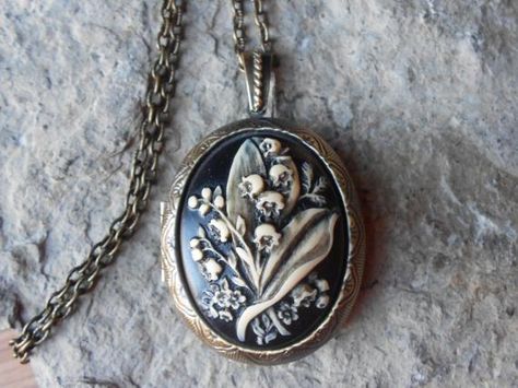 Beautiful cameo locket!!!  The cameo is a gorgeous lily of the valley. Stunning colors, each cameo is individually hand painted and antiqued, each an original!!!  The bronze ans silver plated lockets are victorian style with beautiful scroll on both the front and back about 2" long.  They can hold two photos or a treasured keepsake.  Pass down from generation to generation!!!  The bronze locket includes a 24" adjustable rolo link chain with a lobster claw clasp, and the silver includes a 22" .92 Etiquette Vintage, Funky Jewelry, Silver Lockets, Coin Jewelry, April 26, Jewelry Inspo, Dream Jewelry, Locket Necklace, Pretty Jewellery