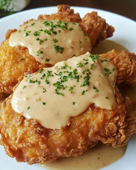 Pan Fried Chicken with Cream Gravy 🍗🍛 Ingredients: - 4 boneless, skinless chicken breasts - 1 cup all-purpose flour - 1 teaspoon paprika - 1/2 teaspoon garlic powder - Salt and pepper, to taste - 1/4 cup vegetable oil - 2 tablespoons unsalted butter - 1 cup whole milk - 1/2 cup chicken broth Instructions: 1. In a shallow bowl, mix flour, paprika, garlic powder, salt, and pepper. Dredge the chicken breasts in the flour mixture, coating well. 2. Heat vegetable oil in a large skillet over me... Garlic Fried Chicken, Chicken Fried Chicken, Homemade Recipe Books, Cream Gravy, Gravy Ingredients, Pan Fried Chicken, Fried Chicken Breast, Shallow Bowl, Boneless Skinless Chicken