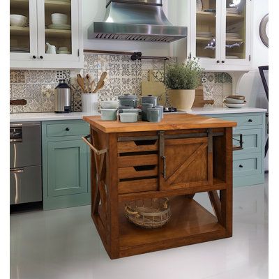 Utility and style go hand-in-hand with this kitchen island. It places an industrial twist on its farmhouse styling. Sleek yet simple, it features a solid butcher block top with a fold-out leaf for seating, a barn-type sliding door, and towel and spice racks on opposite sides. Solid mahogany and mango wood make up the top and base of this piece, respectively, with touches of metal hardware throughout to complete the look. Made in Indonesia. | Gracie Oaks Jaren Kitchen Island Brown 37.0 x 43.5 x 3 Vintage Kitchen Islands, Square Wood Kitchen Island, But Her Block Island, Rustic Kitchen Island Farmhouse Style, Unique Kitchen Island Ideas, Farmstead Kitchen, Butcher Block Kitchen Island, Farmhouse Styling, Freestanding Kitchen Island