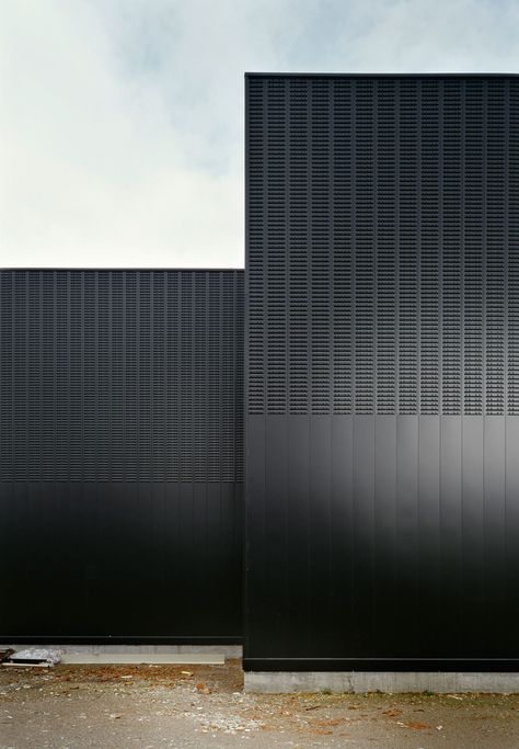 A galvanized steel secondary structure is fixed to this wall, where the steel profiles that complete the ventilated façade are bolted. The profiles are 0,6mm steel sheets, perforated and plain. Black Buildings, Installation Architecture, Black Architecture, Detail Arsitektur, Metal Facade, Metal Cladding, Architecture Building Design, Building Facade, Minimalist Architecture