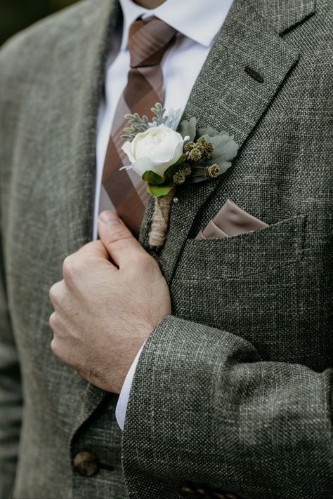 Brown plaid tie and silk pocket square with forest green tweed suit jacket. Artificial silk boutonniere with greenery. Ideas for groom attire and wedding suit inspiration for an autumn lake wedding in Waskesiu Lake, Prince Albert National Park, Saskatchewan, Canada. Intimate lakeside wedding with vintage rustic decor and details at Waskesiu Community Hall by Saskatoon wedding photographer Copperblue Photography and Design. #saskatoon #yxe #yxewedding #saskatchewan #waskesiu