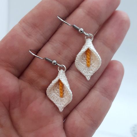 Delicate handmade micro crochet earrings in the shape of a calla flower. The flowers are woven with 100% mercerized cotton thread and measure 2.2 cm. The whole measures 4.4 cm. You can find matching necklaces at the following links: https://theblacksheepthings.etsy.com/listing/1749676973 https://theblacksheepthings.etsy.com/listing/1734924874 Micro Crochet Earrings, Calla Flower, Crochet Thread Patterns, Lily Earrings, String Earrings, Micro Crochet, Crochet Brooch, Crochet Jewelry Patterns, Crochet Earrings Pattern