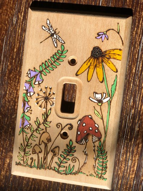 **This is a Made to Order item** Bring the natural world indoors with this sweet meadow design that has been burned into the wood. It is a lovely way to customize a room, whether your style is cottagecore, boho, farmhouse, eclectic, etc.  This light switch cover fits the standard single toggle light switch and includes brass-colored machine screws that blend beautifully with the color of the birch wood. The flowers, mushrooms, and dragonfly are painted and the rest is unfinished wood. The front Mermaid Light Switch Cover, Painted Wall Outlets, Flower Light Switch Cover, Wood Burned Light Switch Cover, Cute Light Switch Art, Clay Lightswitch Cover, Home Decor Cottagecore, Light Cover Painting Ideas, Light Switch Painting Ideas Aesthetic