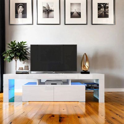 This homey TV stand with LTD is ideal for home lovers. Featuring two drawers and glass shelves, aluminum handles as well as plenty of ample storage space for your gaming consoles you can easily and neatly organize wires or cords with this great piece of unit. Ebern Designs | Ebern Designs Modern TV Stand for 60 inch TVs, TV Stand w/ 20 LED Lights, TV Stands w/ Storage Drawer Brown, Solid + Manufactured Wood | C111989932 | Wayfair Canada Led Lights Tv, Organize Wires, Color Led Lights, Modern Farmhouse Bathroom Rug, Organizing Wires, Tv Stand With Storage, Modern Tv Stand, Tv Stands And Entertainment Centers, Modern Tv