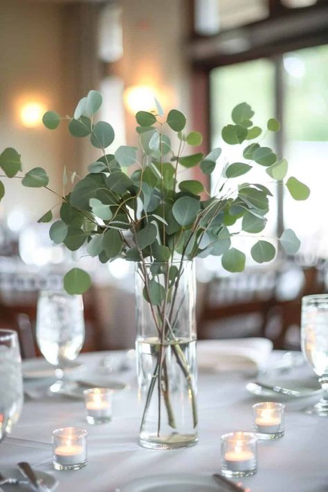 12 Beautiful Eucalyptus Centerpieces For Your Big Day • Eucalyptus Wedding Centrepiece, Wine Bottle Centerpieces Eucalyptus, Diy Eucalyptus Wedding Decor, Eucalyptus Flower Centerpiece, Industrial Wedding Centerpieces Diy, Eucalyptus Wedding Vase, Green Centerpiece Ideas, Eucalyptus Table Numbers, White And Eucalyptus Wedding Decor