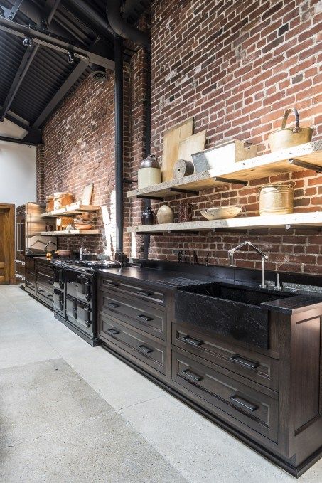 brick wall and dark finishes, concrete floor Black Kitchen With Concrete Floor, Loft Kitchen Design, Industrial Brick Wall, Kitchen With Brick, Dark Brick Wall, Inside Cabin, Brick Wall Kitchen, Warehouse Kitchen, Industrial Kitchen Design