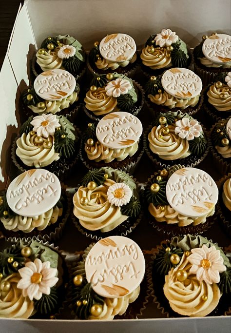 Row of chocolate cupcake with icing in various shades of green. Some have white flowers on top whilst others have a plaque with the couples name. Icing is piped in various swirls to represent a tropical garden. Engagement Party Green And Gold, Cupcakes Engagement Party, Sage Green Cupcakes Wedding, Boho Cupcakes Wedding, Botanical Cupcakes, Engagement Cupcake Ideas, Cupcakes For A Wedding, Boho Cakes, Engagement Party Cupcakes