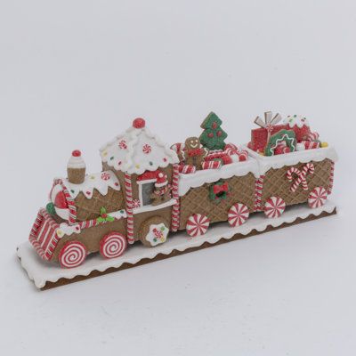 Add an extra bit of whimsy to your Christmas holiday decor with this 19.5-inch-long gingerbread train. Artfully crafted with high-quality clay fixed to a sturdy metal base, this gingerbread train is full of details - you will find something new every time you look! Tiny peppermints, decorated wreaths, and beautifully wrapped presents are just a few of the items Santa is delivering on the train, all dusted in a beautiful shimmering glitter. Place this train on any flat surface in your home to add