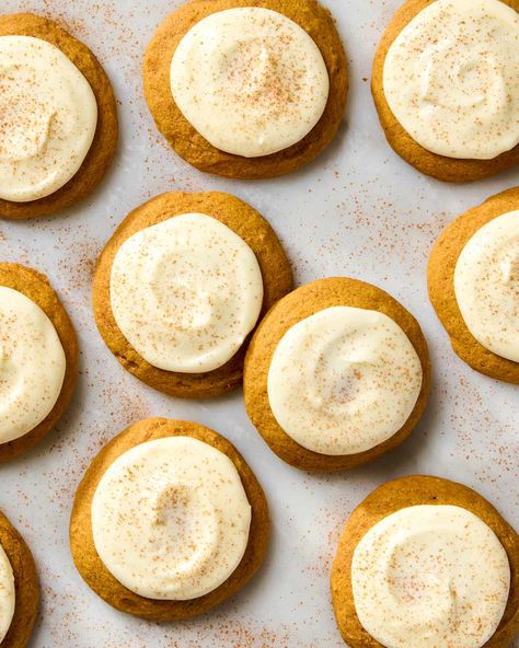 overhead shot of pumpkin spice cookies with cream cheese frosting on parchment paper Pumpkin Cookies Cream Cheese Frosting, Pumpkin Cookies With Cream Cheese Icing, Soft Pumpkin Cookie Recipe, Pumpkin Cookies Recipe, Pumpkin Spice Cookie Recipe, Autumn Drink, Pumpkin Cookies Healthy, Magical Food, Cream Cheese Cookie Recipe