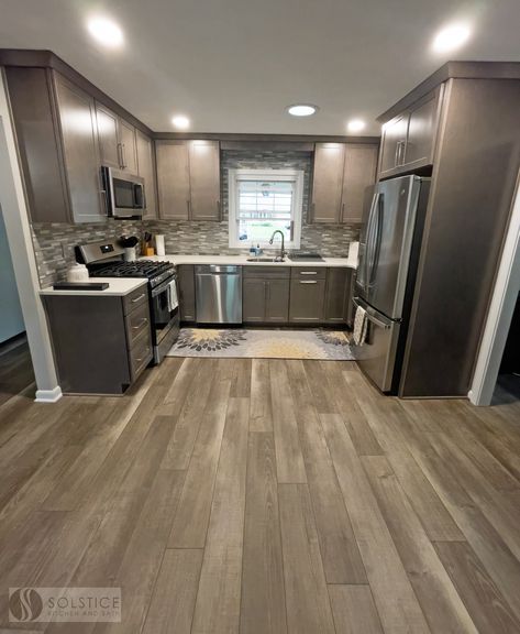 Give your #kitchendesign the warmth of a wood floor with the durability of vinyl like this #BowieMD #kitchenremodel. Armstrong Flooring Woodward Winds in beige breeze luxury vinyl plank flooring is perfect for a high moisture area with heavy traffic. ➡️ Call us at (410) 451-3456 to start planning your design today! Brown Lvp Flooring Kitchen, Vynil Flooring Kitchen, Wood Vynil Flooring Ideas, House Cupboards, Kitchen Wood Flooring Ideas, Brown Kitchen Tiles, Kitchen Flooring Ideas Vinyl, Vinyl Plank Flooring Kitchen, Brown Kitchen Ideas