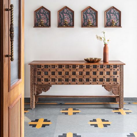 This home - Prangan, has a lot of vintage, repurposed furniture that we have used.

To keep it authentic to the style, we travelled to Kochi to source these pieces and they literally are conversation starters in this home.

This gorgeous teak console has the most detailed carvings and probably repurposed from a door and the corbels add to its vintage charm.

Above the console are shelves that were made on site and they house these antique brass sculptures depicting musicians of the bygone era (again from Kochi) ❤️

#studioipsa #foyer #enteranceflooring #foyerconsole #vintageIndian console #vintagecharm #brassaccents # Entryway Indian Decor, Entryway Table Decor Indian, Console Table India, South Indian Furniture, Console Table Decorating Indian Style, Foyer Flooring, Indian Interiors, Ethnic Decor, Foyer Decor