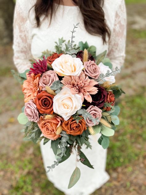 These STUNNING arrangements are made from high quality silk and foam flowers. Get the look of real flowers without the astronomical price!  Cake flowers can be found here: https://www.etsy.com/OurBlessedWoods/listing/1453755023/terracotta-burgundy-and-dusty-rose-cake?utm_source=Copy&utm_medium=ListingManager&utm_campaign=Share&utm_term=so.lmsm&share_time=1680549182330 Dog collar found here: https://ourblessedwoods.etsy.com/listing/1573406278/wedding-dog-collar-floral-ring-dog Bridal measures app Bridal Flowers Bouquet Fall, Burnt Orange And Burgundy Wedding, Terracotta And Burgundy, Dusty Rose Fall Wedding, Rose Fall Wedding, Orange Bridal Bouquet, October Wedding Flowers, October Vibes, Fall Wedding Bouquet