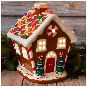 Dimensions: 10" H x 7.16" W x 7.48" D Power Source: Corded Electric Material: Ceramic & Glass Color: Brown, White, Red & Green Pattern: Stripes Care & Safety: Indoor Use Only Quantity: 1 Make your Christmas village display look brighter when you add this Light Up Gingerbread House! This charming ceramic house looks exactly like a gingerbread house, but without the frosting! Its colorful round spheres on top light up and give off a vibrant appearance. Simply turn on the lights to make your holida Gingerbread Cookie House, Up Gingerbread House, Faux Gingerbread, Cookie House, Christmas Village Display, Berry Garland, Village Display, Diy Christmas Decorations Easy, Decor Pillows