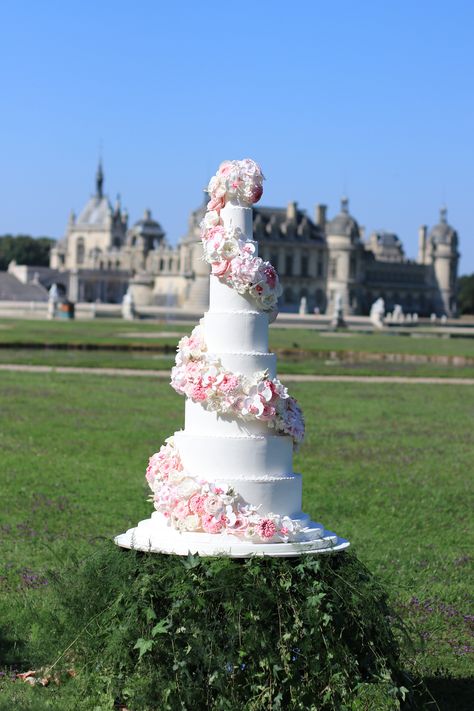 Luxury wedding cake from Bastien Blanc-Tailleur.  Wedding cake created in July 2019 at the magnificent chantilly castle for a wedding shooting. This cake is 1m50 tall and is decorated with a spiral of flowers. This swirl are composed of more than 300 different handmade sugar flowers that required several weeks to make : David austin roses - renonculus - hydrangea - orchids - jasmin - baccarat roses - lisianthus - chrysanthem Chantilly Castle, Spiral Cake, Jasmine Wedding, Quince Decorations, Wedding Shooting, Floral Wedding Cake, Luxury Wedding Cake, Cool Wedding Cakes, David Austin Roses