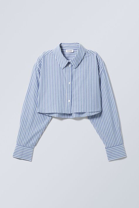 A cropped buttoned shirt made from crisp and soft chambray. It has a pointed collar, a box pleat, buttoned cuffs, and a straight hemline. Kemeja Crop Top, Cropped Button Up, Camisa Crop Top Outfit, Crop Shirt Outfits, Cropped Button Up Shirt Outfit, Cropped Dress Shirt, Crop Button Up Shirt, Cropped Shirt Outfit, Crop Shirts For Women