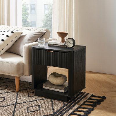 Discover the Cathlino Nightstand, a perfect fusion of modern aesthetics and functionality. This unique piece highlights a distinctive fluted waveform panel, meticulously created using innovative techniques, exuding an essence of elegance. The oak laminate, with its natural grains and textures, brings a touch of the outdoors inside. Its gentle, curved edges not only enhance the visual appeal of your bedroom but also ensure safety for the little ones. The smooth gliding drawer offers practical sto Black Rattan Nightstand, Black Fluted Nightstand, Wavy Nightstand, Fun Nightstand, Black Nightstand Bedroom, Black Night Stand, Condo Makeover, Open Nightstand, Bedside Table Round