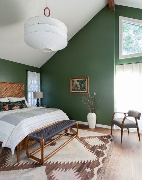 an attic mid century modern bedroom with green walls, wood and rattan furniture, an oversized lamp and a printed rug Green Bedroom Walls, Green Bedroom Design, Green Bedroom Decor, Airy Bedroom, Green Accent Walls, Green Interior Design, Lakeside Cabin, Mid Century Modern Bedroom, Gorgeous Bedrooms