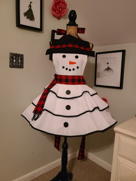 "This adorable Snowman Retro Style Hostess Apron will get you in the festive mood and delight your guests. Full circle skirt, fully lined bodice. Buttons used for Eyes, Mouth and Front Buttons on Skirt. Material: 100% Cotton Fabric/Bias Piping Trim: Poly/Cotton Measurements: Across Bodice (Hat Brim): 15\" Neck Ties: 33\" Waist Ties/Sashes: 40\" each Skirt Length: 15 1/2\" Top of Bodice to Bottom of Skirt: 30\" Fits Sizes S/M/L Best Care Instructions: Hand Wash Only, Line Dry, Iron as Needed. Pet Holiday Aprons Christmas, Gingerbread Apron Diy, Christmas Aprons Diy, Christmas Aprons Ideas, Sew Apron, Whoville Costumes, Gingerbread Apron, Dress Up Aprons, Homemade Aprons