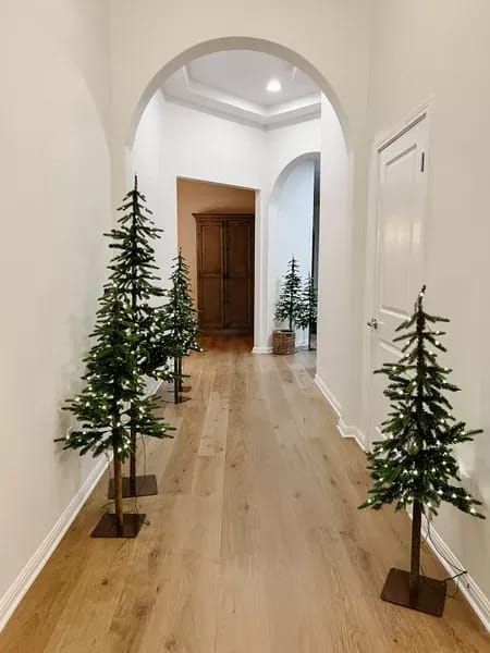 Prelit Christmas trees to line an arched hallway. Love how this makes Caila’s home look like a winter wonderland. Great Target holiday find #LTKstyletip #LTKunder100 #LTKHoliday Hallway Christmas Tree, Long Hallway Christmas Decor Ideas, Entry Way Christmas Trees, Arch Way Christmas Decorations, Christmas Tree In Foyer, Christmas Hallway Decorations, Hallway Christmas Decor, Arched Hallway, Alpine Christmas Tree