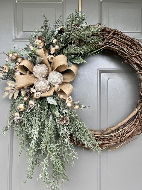 "New for the holidays is this elegant wreath, all decked in gold and ready to help you welcome your family and friends this holiday. The gold-flocked berries create a festive look on the wreath with the glistening evergreen cypress branches.  I added frosted holly branches to accent the platinum ornaments I placed on a beige bow with sparkling gold.  I used an 18\" grapevine wreath and quality faux branches to create this unique design that is perfect for your holiday decor and to enjoy through the winter season.  Please keep in mind that if you display it on your outside door, it should have coverage from the elements, such as rain, snow, sleet, or harsh weather conditions to preserve the beauty of your wreath. Thank you for taking the time to visit this listing.  I appreciate your intere Modern Christmas Door Decor, Chic Christmas Wreath, Angel Christmas Wreath, Minimalist Winter Wreath, Christmas Wreaths Grinch, Boho Christmas Wreaths For Front Door, Christian Christmas Wreath, Christmas Neutral Decor, Christmas Wreaths Diy Easy How To Make