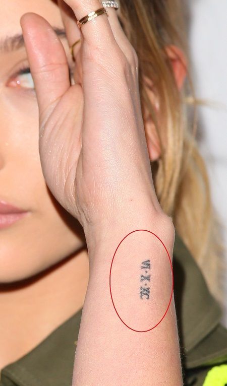 The Roman numeral tattoo stands for June 10, 1990, which is the date when her parents got married. Tiny Date Tattoos For Women, Hailey Bieber Wrist Tattoo, Roman Numeral Seven Tattoo, Roman Numeral Tattoo Meaning, Roman Numeral Tattoos Women, Wrist Roman Numeral Tattoo, Roman Numeral Tattoo Women, Small Date Tattoos, Dainty Roman Numeral Tattoo