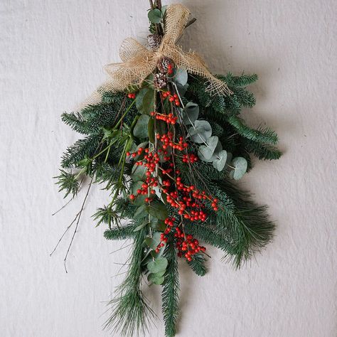 This Christmas teardrop wreath is a classic blend of festive foliage and berries will not disappoint. Teardrop swags are incredibly versatile and the options are endless: on a door, over the back of dining chairs, on a bannister, over the fireplace or as a wall decoration. If displayed outdoors, hang in a sheltered spot, such as under a porch or canopy. Christmas swags are also displayed on a mantel or as a decoration on your dining table to create a truly festive centrepiece. Please Note: Hessi Christmas Flower Arrangements Ideas, Flower Garden Aesthetic, Flower Arrangements Ideas, Teardrop Wreath, Winter Flower Arrangements, Garland Making, Christmas Door Hangings, Winter Floral Arrangements, Floral Door Wreaths